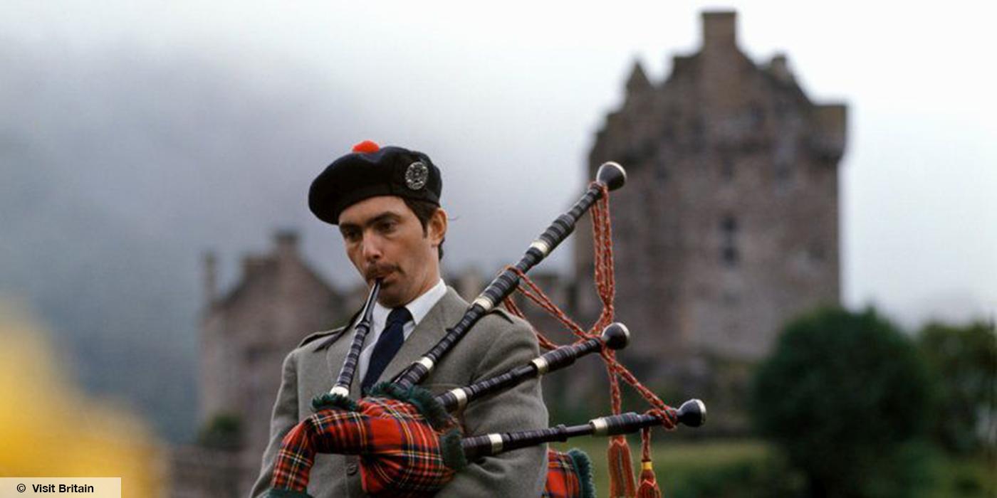 Man with bagpipes, Eilean Donan Castle, Highlands,© Visit Britain